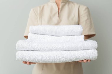 Hafif arka planda temiz yumuşak havluları olan bir kadın.