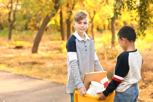 屋外でゴミを集める小さな子供たち。リサイクルの概念 — ストック写真