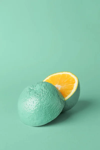 Розфарбований бірюзовий апельсин на кольоровому фоні — стокове фото