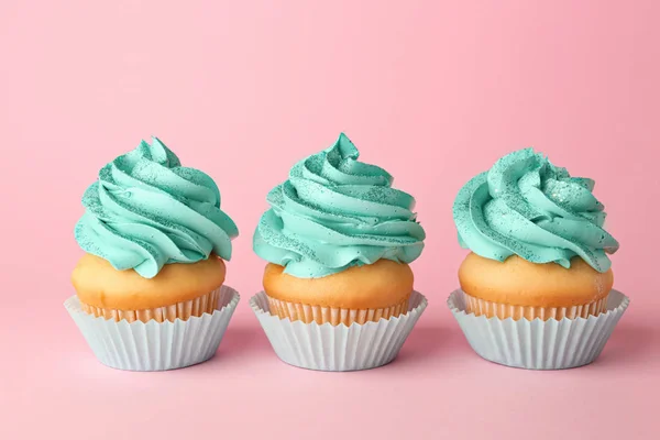 Leckere Cupcakes auf farbigem Hintergrund — Stockfoto