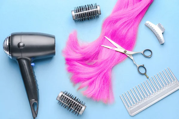 Hairdresser tools and accessories on color background