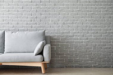 Tuğla duvarın yanındaki yumuşak kanepe