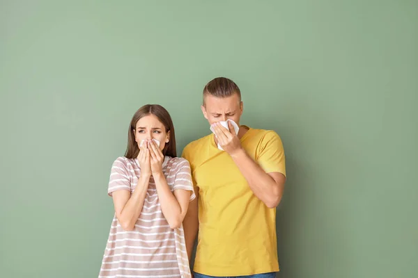 Casal jovem que sofre de alergia no fundo da cor — Fotografia de Stock