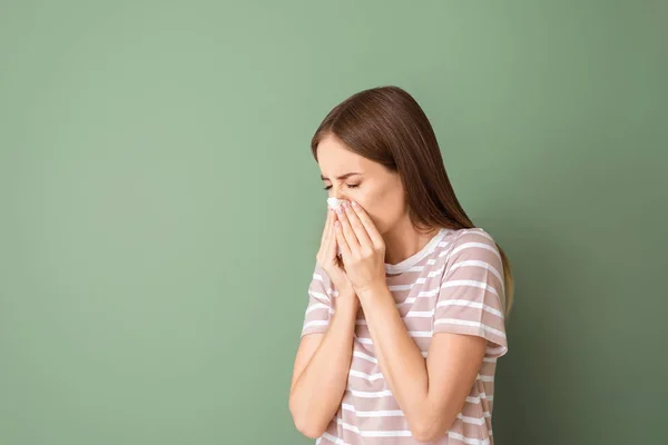 Mujer joven que sufre de alergia en el fondo del color — Foto de Stock