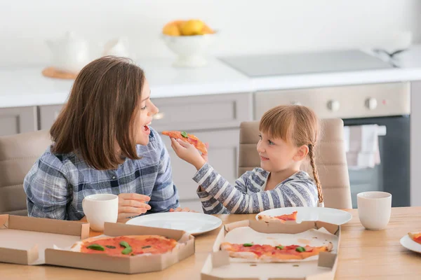 Šťastná matka a její dceruška pojímají pizzu doma — Stock fotografie