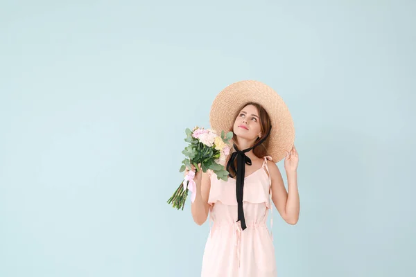 Beautiful young woman with bouquet of carnation flowers on color background — Stock Photo, Image