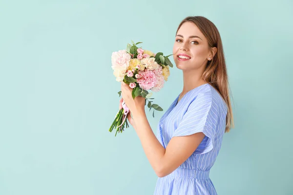 Красивая молодая женщина с букет гвоздичных цветов на цветном фоне — стоковое фото