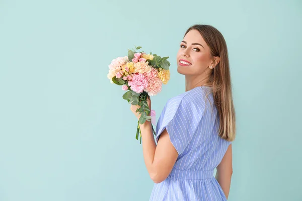 Beautiful young woman with bouquet of carnation flowers on color background — Stock Photo, Image