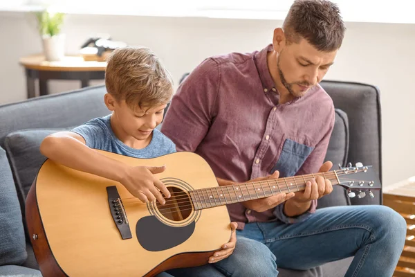 Father teaching his little son to play guitar at home — Stock Photo, Image