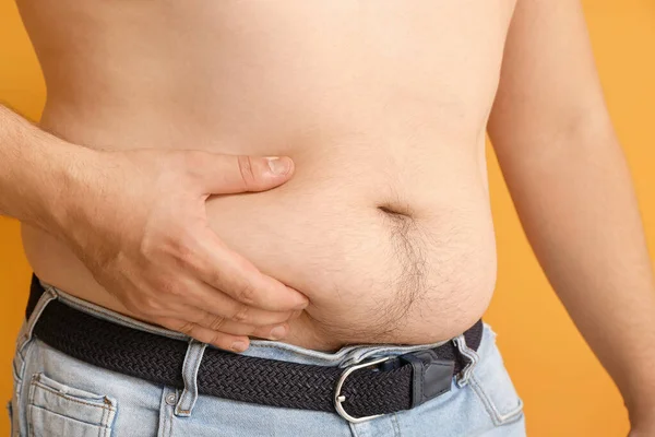 Uomo sovrappeso che tocca il grasso sulla pancia, primo piano. Perdita di peso concetto — Foto Stock