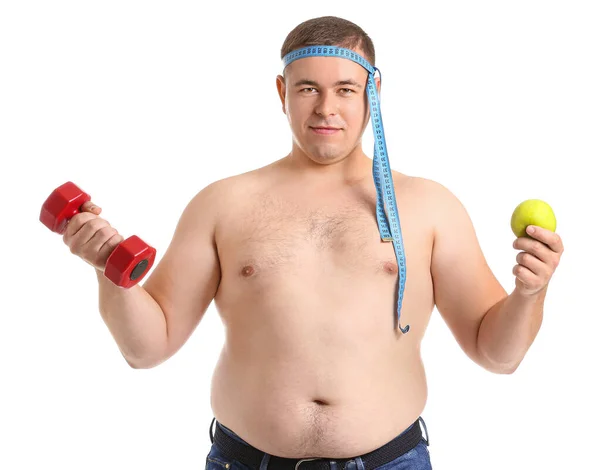 Uomo sovrappeso con manubrio, metro a nastro e mela su sfondo bianco. Perdita di peso concetto — Foto Stock