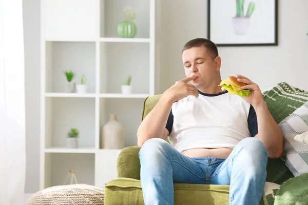 Избыточный вес человек ест нездоровую пищу в домашних условиях — стоковое фото