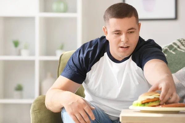 Избыточный вес человек ест нездоровую пищу в домашних условиях — стоковое фото