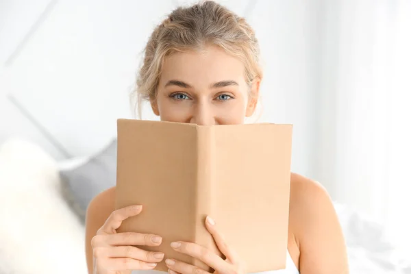 Morning of beautiful young woman with book in bedroom — Stock Photo, Image