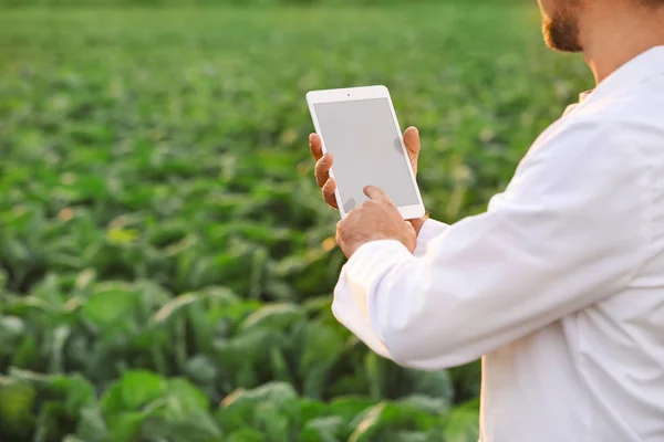 Male agricultural engineer working in field — ストック写真