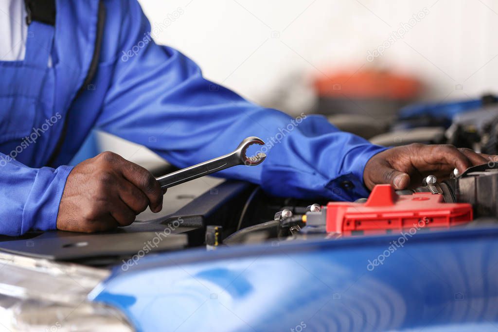 African-American mechanic working in car service center, closeup