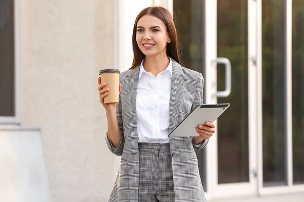 Hermosa joven empresaria con café y tableta al aire libre — Foto de Stock