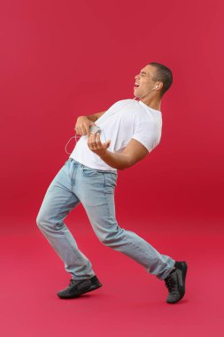 Renkli arka planda müzik dinleyen yakışıklı bir gencin portresi