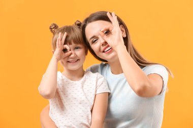 Mutlu anne ve kızın portresi Tamam jestini renk arkaplanında gösteriyor