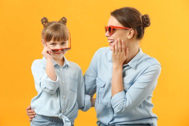 Renkli arka planda şık bir anne ve kızın portresi