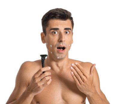 Beyaz arka planda ustura ile şok olmuş genç bir adam.