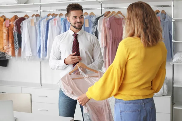 Trabajador masculino mostrando ropa limpia al cliente en la moderna tintorería — Foto de Stock