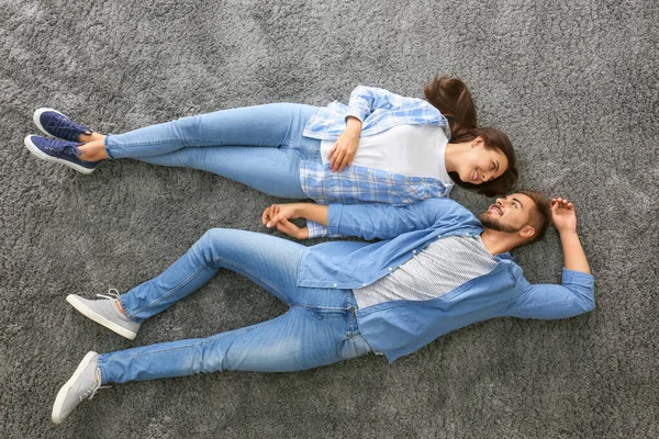 Retrato de hermosa pareja joven tumbada en el suelo, vista superior —  Fotos de Stock