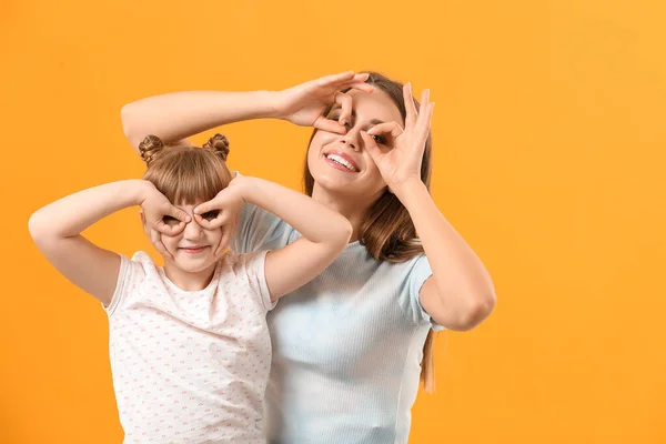 Portrait of happy mother and daughter having fun on color background — Stock Photo, Image