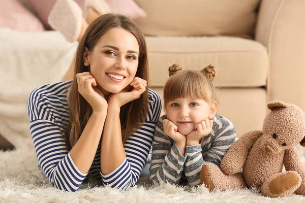 Portret van gelukkige moeder en dochter liggen op de vloer thuis — Stockfoto