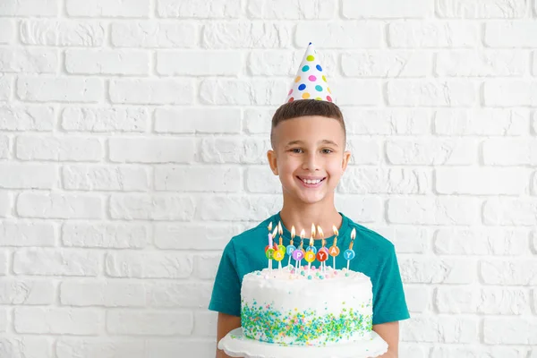 Μικρό αγόρι με τούρτα γενεθλίων σε λευκό φόντο τούβλο — Φωτογραφία Αρχείου