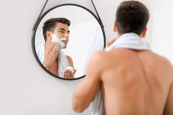 Schöner junger Mann rasiert sich zu Hause — Stockfoto