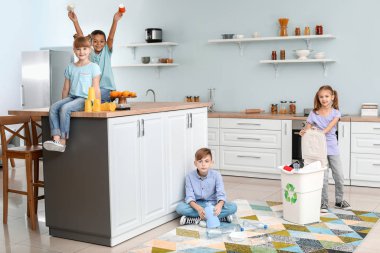 Mutfakta çöp kutusu olan küçük çocuklar. Geri dönüşüm kavramı