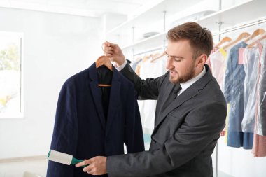 Modern kuru temizlemecideki genç erkek işçi.