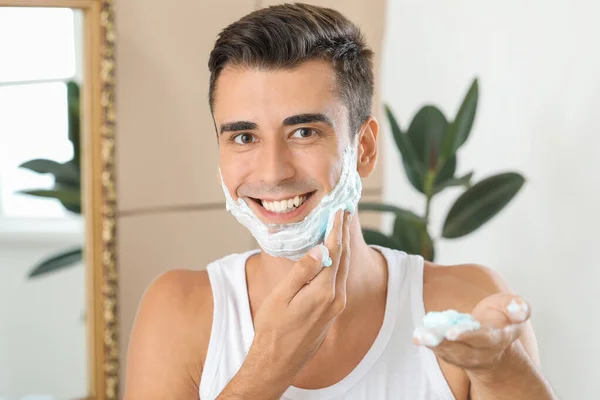 Joven guapo afeitándose en el baño — Foto de Stock