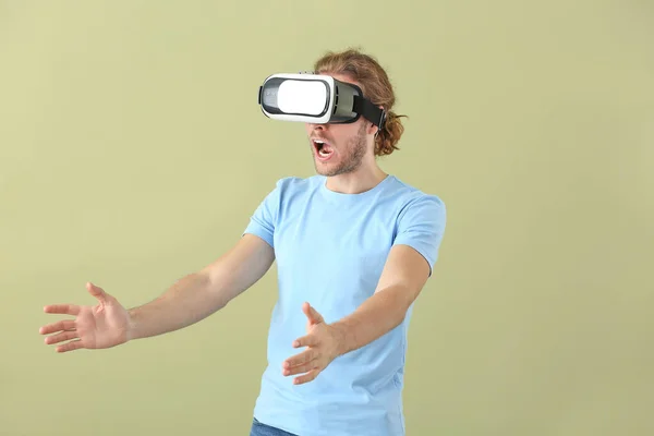 Ung man med VR glasögon på färg bakgrund — Stockfoto
