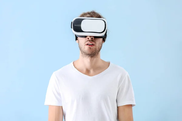 Junger Mann mit VR-Brille auf farbigem Hintergrund — Stockfoto