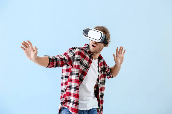 Junger Mann mit VR-Brille auf farbigem Hintergrund — Stockfoto