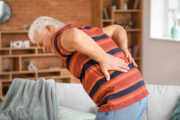Hombre mayor que sufre de dolor de espalda en casa — Foto de Stock