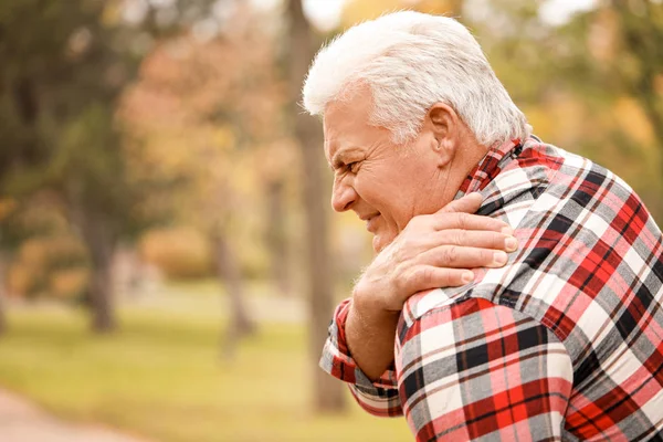Senior man suffering from back pain outdoors — Stock Photo, Image