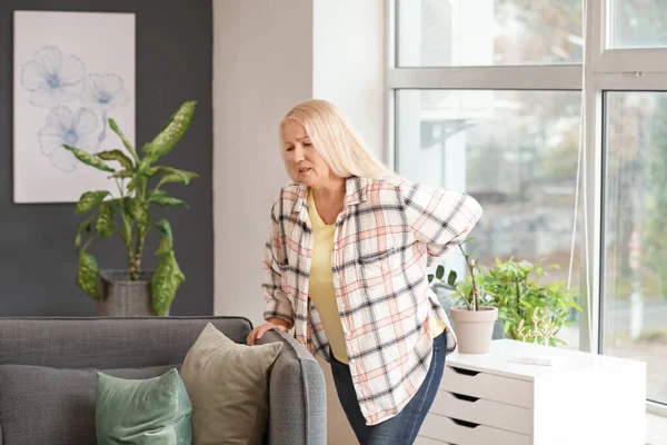 Mature woman suffering from back pain at home — Stock Photo, Image