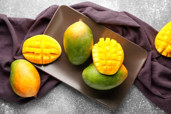 Plate with sweet ripe mangoes on grey background — Stock Photo, Image