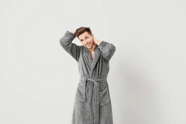 Handsome man in bathrobe on grey background — Stock Photo, Image