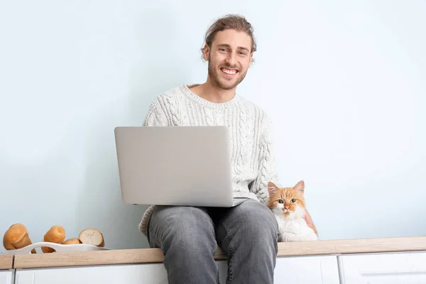 Hombre con portátil y su lindo gato en la cocina —  Fotos de Stock