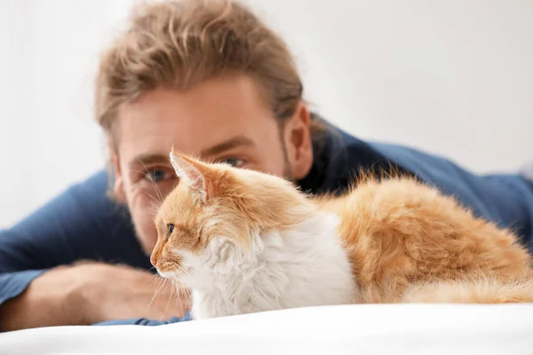Man with cute cat in bedroom — Stock Photo, Image