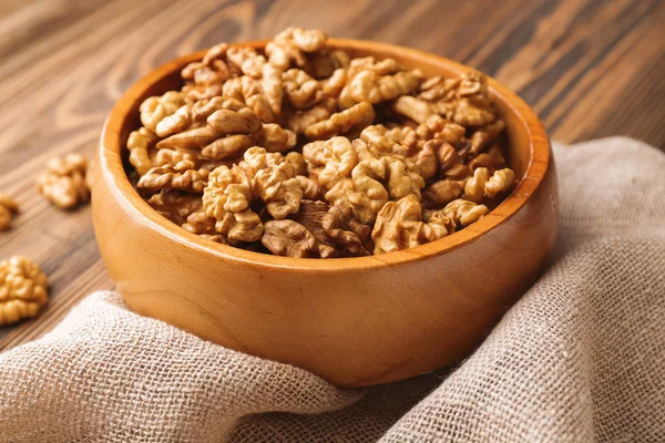 Bowl with tasty walnuts on wooden table — Stock Photo, Image