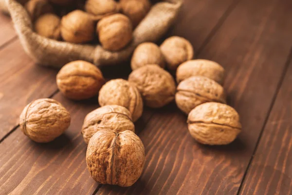 Мешок с вкусными грецкими орехами на деревянном столе — стоковое фото
