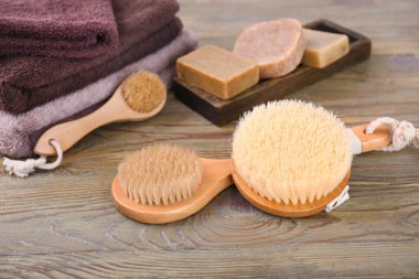 Ahşap arka planda banyo için fırçalar ve sabunlar