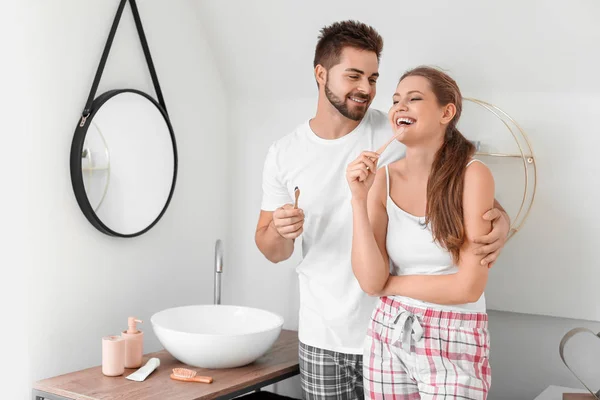 Вранці молода пара чистить зуби у ванній — стокове фото