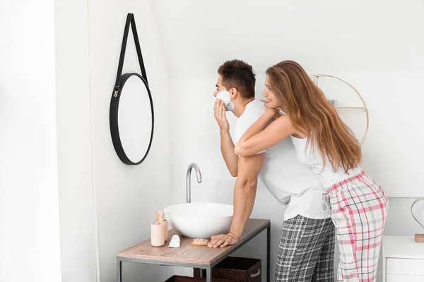 Morgon med vacker ung kvinna och hennes man med raklödder i ansiktet i badrummet — Stockfoto