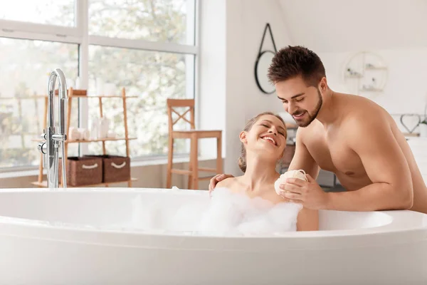 아내가 목욕하는 것을 도와 주는 젊은 남자 — 스톡 사진
